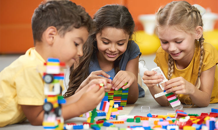 kids gathered around legos at shops in bend, oregon.