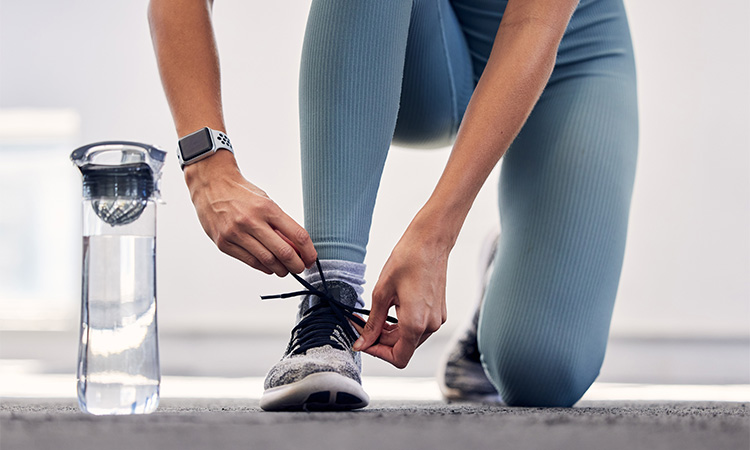 a close up of someone tying the laces on their new sneakers they got while on a bend oregon shopping spree.