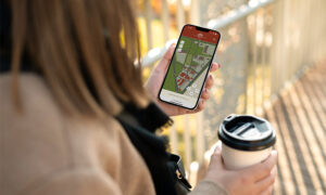 woman holding phone showing a map of the cascade village shopping center